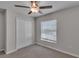 Bedroom view features a ceiling fan, window with blinds, and a double-door closet at 10357 Scarlet Skimmer Dr, Riverview, FL 33578