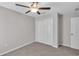 Carpeted bedroom features a ceiling fan and large closet at 10357 Scarlet Skimmer Dr, Riverview, FL 33578
