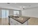 Kitchen island features stainless steel dishwasher, double sink, granite countertops and a ceiling fan at 10357 Scarlet Skimmer Dr, Riverview, FL 33578
