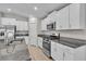 Kitchen features white cabinets, stainless steel appliances, and granite countertops at 10357 Scarlet Skimmer Dr, Riverview, FL 33578