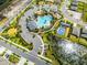 Aerial view of community pool, clubhouse, and basketball court, with ample parking and sidewalks throughout the neighborhood at 1220 Tahitian Sunrise Dr, Plant City, FL 33565