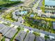Aerial view of neighborhood amenities including a pool, basketball court, and community green spaces among the homes at 1220 Tahitian Sunrise Dr, Plant City, FL 33565