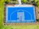 Aerial view of a blue basketball court with a black fence, set in a green landscaped space for community recreation at 1220 Tahitian Sunrise Dr, Plant City, FL 33565