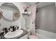 Bathroom featuring a grey-tiled shower and decorative pink accents at 1220 Tahitian Sunrise Dr, Plant City, FL 33565