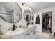 Bright bathroom featuring double sinks, modern mirrors, and a walk-in closet at 1220 Tahitian Sunrise Dr, Plant City, FL 33565