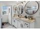 Bathroom featuring a double vanity with black fixtures, stylish mirrors, and a shower at 1220 Tahitian Sunrise Dr, Plant City, FL 33565