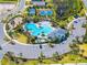 An aerial view showcasing a community pool, playground, tennis courts, and clubhouse surrounded by sidewalks at 1220 Tahitian Sunrise Dr, Plant City, FL 33565