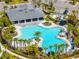 Aerial view of community pool with palm trees, lounge chairs, covered seating, and beautiful landscaping throughout at 1220 Tahitian Sunrise Dr, Plant City, FL 33565