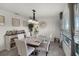 Bright dining room featuring a modern chandelier, large window, and neutral-toned decor at 1220 Tahitian Sunrise Dr, Plant City, FL 33565