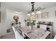 Bright dining room featuring a modern chandelier, large window, and neutral-toned decor at 1220 Tahitian Sunrise Dr, Plant City, FL 33565