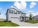 Charming two-story home featuring a well-manicured lawn, gray shutters, covered porch, and two-car garage at 1220 Tahitian Sunrise Dr, Plant City, FL 33565