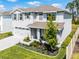 Charming two-story home featuring a well-manicured lawn, gray shutters, covered porch, and two-car garage at 1220 Tahitian Sunrise Dr, Plant City, FL 33565