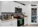 Cozy kitchen with white cabinets, stainless steel microwave, and open pantry storage at 1220 Tahitian Sunrise Dr, Plant City, FL 33565