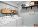 Well-organized laundry room with washer, dryer, and shelving at 1220 Tahitian Sunrise Dr, Plant City, FL 33565