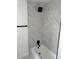 Updated bathroom shower featuring modern black fixtures and marble-look tile surround at 12219 Armenia Gables Cir, Tampa, FL 33612