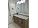 Bathroom vanity with granite countertop, wood cabinets, black fixtures, and bright vanity lighting at 12219 Armenia Gables Cir, Tampa, FL 33612