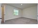 Inviting bedroom featuring neutral carpeting and a window providing natural light at 1570 Hubbell Rd, Wesley Chapel, FL 33543