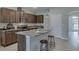 Well-equipped kitchen featuring stainless steel appliances, granite counters, breakfast bar, and stylish bar stools at 1570 Hubbell Rd, Wesley Chapel, FL 33543