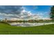 Scenic view of the community pond reflecting the blue sky and fluffy white clouds above at 1570 Hubbell Rd, Wesley Chapel, FL 33543