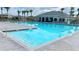 Large community swimming pool with lounge chairs and palm trees in a tropical setting at 1570 Hubbell Rd, Wesley Chapel, FL 33543