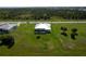 Back aerial view showing pool, screen enclosure, well-manicured lawn and mature trees at 205 Rotonda S Blvd, Rotonda West, FL 33947