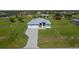 Aerial view of the home showcasing its well-manicured lawn and gray brick driveway at 205 Rotonda S Blvd, Rotonda West, FL 33947
