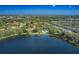 Aerial view of community featuring a lake, pool, and residential buildings surrounded by trees at 2055 Lakeview Dr, Clearwater, FL 33763
