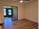 Bedroom with wood-look flooring, ceiling fan, and sliding glass doors to a screened porch at 2055 Lakeview Dr, Clearwater, FL 33763