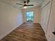 Bright bedroom featuring wood floors, ceiling fan, and a window with a view at 2055 Lakeview Dr, Clearwater, FL 33763