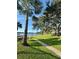 A paved walkway leads along the manicured lawn, offering scenic views of the lake and the surrounding trees at 2055 Lakeview Dr, Clearwater, FL 33763