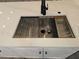 Close-up of a modern kitchen sink with accessories and black faucet against a white countertop at 2055 Lakeview Dr, Clearwater, FL 33763