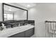 Modern bathroom with double sinks, a large mirror, and black accent tiles at 4043 Topsail Trl, New Port Richey, FL 34652