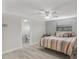 Bedroom with a ceiling fan, window and an adjacent bathroom with wood-look laminate flooring at 4043 Topsail Trl, New Port Richey, FL 34652