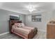 Bedroom features a ceiling fan, wood-look floors, and a window with blinds at 4043 Topsail Trl, New Port Richey, FL 34652