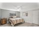 Cozy bedroom with a ceiling fan, gray walls, wood floors and a colorful striped bedspread at 4043 Topsail Trl, New Port Richey, FL 34652