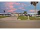 Attractive single-story home featuring a paved driveway, manicured lawn, and tropical landscaping at 4043 Topsail Trl, New Port Richey, FL 34652