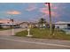 Charming single-story home featuring lush front yard, a palm tree, and a paved driveway at sunset at 4043 Topsail Trl, New Port Richey, FL 34652