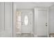 Bright foyer with light wood floors, a decorative glass front door and white interior doors at 4043 Topsail Trl, New Port Richey, FL 34652