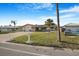 Single-story home boasts a brick driveway, green lawn, and mature palms in a well-maintained front yard at 4043 Topsail Trl, New Port Richey, FL 34652