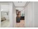 Hallway leading to kitchen area with wood-look floors and bright white walls at 4043 Topsail Trl, New Port Richey, FL 34652