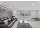 Relaxing living room features a leather sofa and chair, neutral walls, and bright windows with a view at 4043 Topsail Trl, New Port Richey, FL 34652