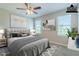 Virtually staged primary bedroom with ceiling fan, two windows, and neutral decor at 507 Daylily Blvd, Nokomis, FL 34275