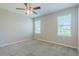 Bedroom with neutral walls, carpeted floor, two windows and ceiling fan at 507 Daylily Blvd, Nokomis, FL 34275