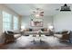 Staged living room with a gray sofa, matching chairs and a marble coffee table at 507 Daylily Blvd, Nokomis, FL 34275
