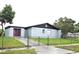 Exterior home view features a chain-link fence, grassy lawn, and a single window at 2202 Whitney Pl, Valrico, FL 33594