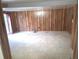 Open living room featuring tile flooring, wood paneling, and sliding glass doors at 2202 Whitney Pl, Valrico, FL 33594