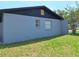 Single-story home featuring a light gray exterior with windows at 2202 Whitney Pl, Valrico, FL 33594