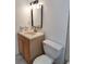 Modest bathroom with a single vanity, modern lighting fixture, toilet, and a framed mirror at 3716 Mistwood Dr, Tampa, FL 33619