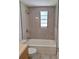 Contemporary bathroom featuring gray tiled walls, a shower, and a window providing natural light at 3716 Mistwood Dr, Tampa, FL 33619