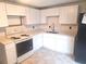 Bright kitchen featuring white cabinets, countertops, and appliances, with tile flooring at 3716 Mistwood Dr, Tampa, FL 33619